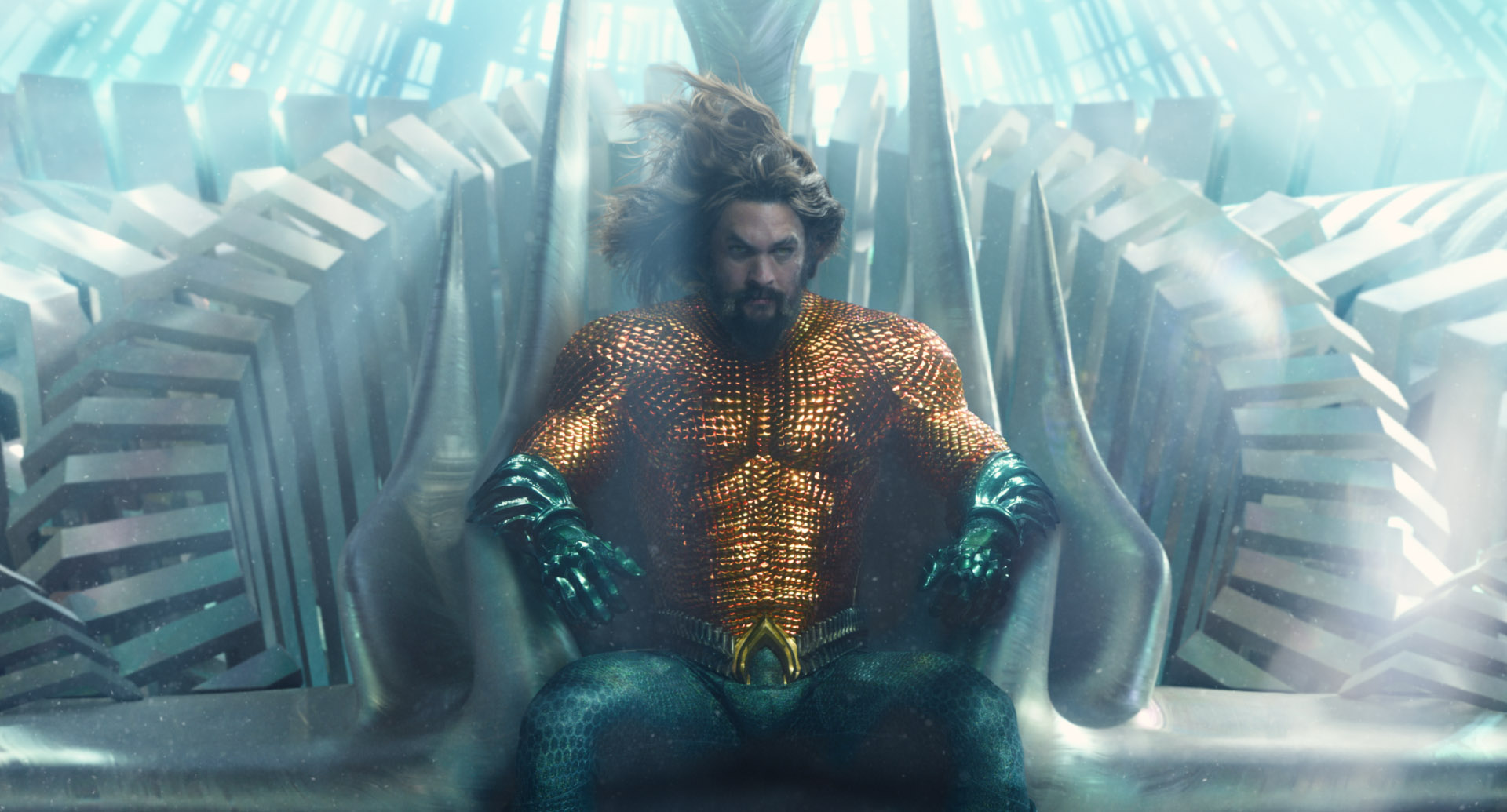 Aquaman sits on a throne in the water