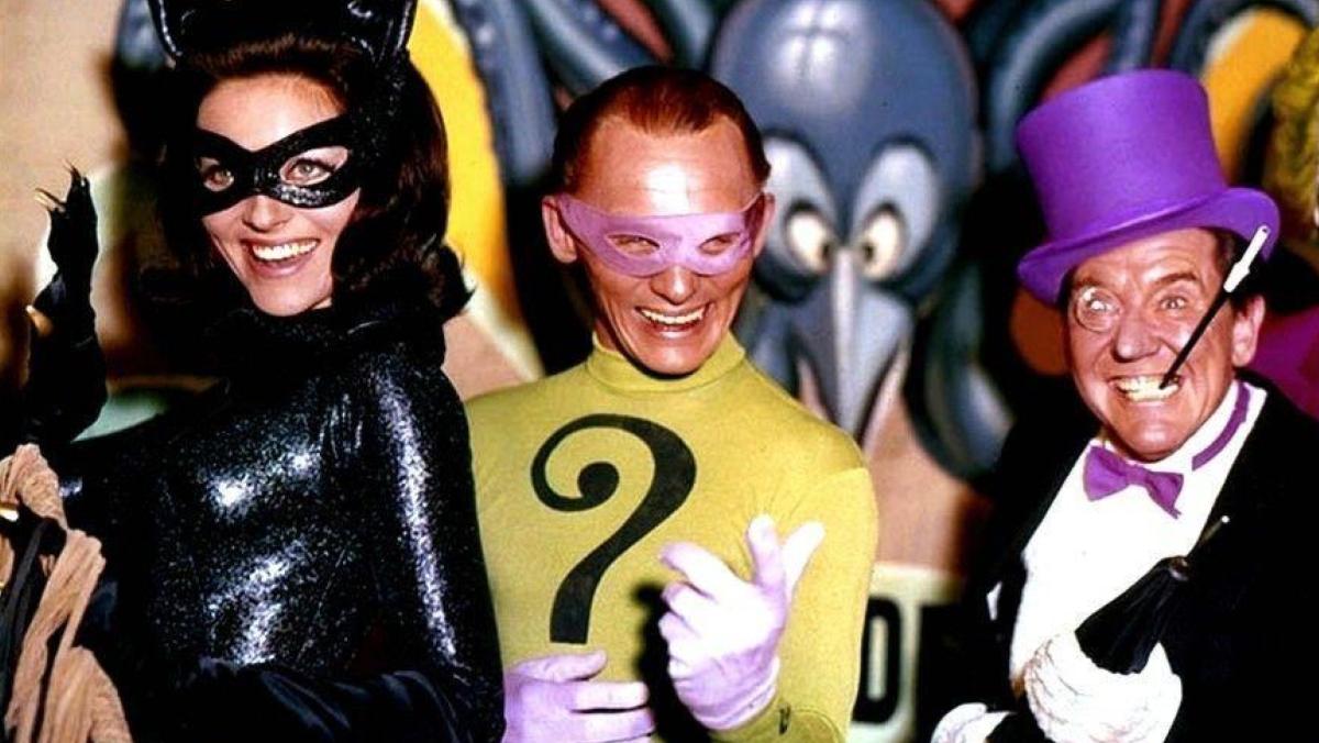 A still from Batman 66 shows Julie Newmar, Frank Gorshin, and Burgess Meredith as Catwoman, Riddler, and Penguin respectively