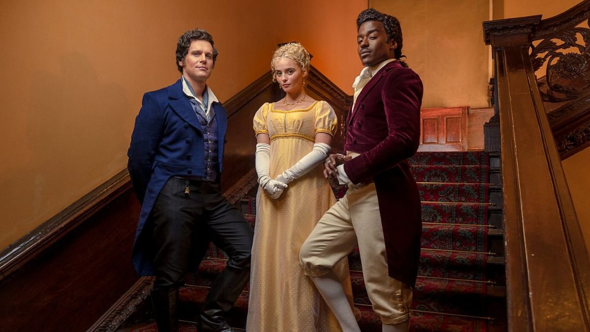 photo of Ncuti Gatwa, Millie Gibson, and Doctor Who guest star Jonathan Groff standing on stairs with historical clothing 