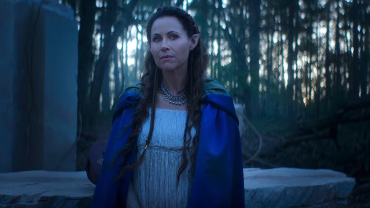 Minnie driver as an elf in a blue robe in front of a stone table on The Witcher: Blood Origin