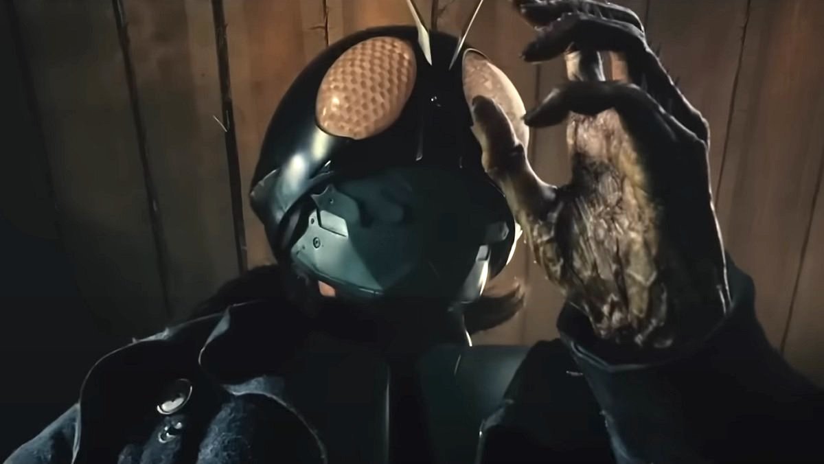 Takeshi Hongo wears his bug-like motorcycle helmet and looks at his mutating hand in the trailer for Shin Kamen Rider.