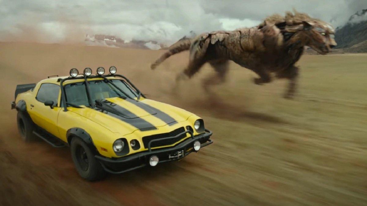 Bumblebee in Camaro form speeds through the open plains next to Cheetor in giant cheetah form in Transformers: Rise of the Beasts.